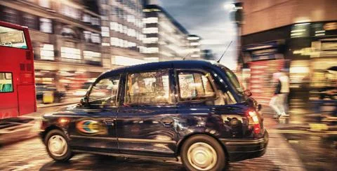 Motion blur picture of Black Cab at major road intersection in London nigh... Photos