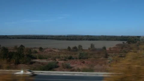 Motion blur view from train window showing expansive landscape under clear blue Stock-Footage 335764204