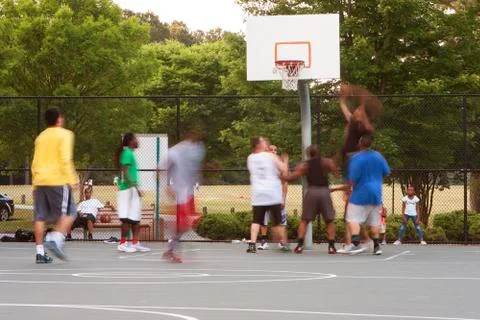 Motion Blur of Young Men Playing Playground Basketball Game Foto stock