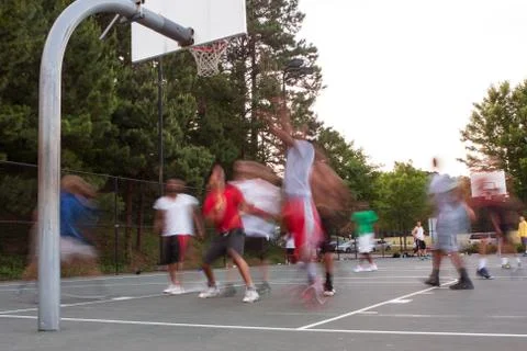 Motion Blur Of Young Men Playing Pickup Basketball Game Foto stock