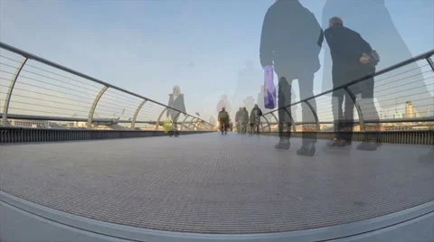 Motion blurred commuters flow along Millennium Bridge in time-lapse footage 스톡 동영상 56168884
