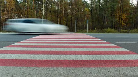 Motion blurred image of super fast driving car on road crosswalk Stock Photos