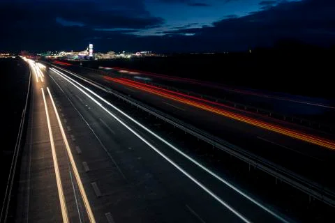 Motion blurred light tracks glowing to the darkness of highway traffic Stock Photos