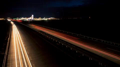 Motion blurred light tracks glowing to the darkness of highway traffic Stock Photos