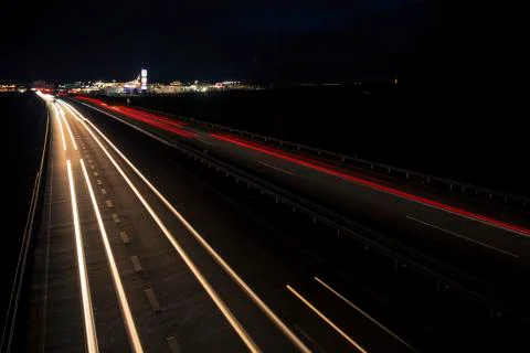 Motion blurred light tracks glowing to the darkness of highway traffic Stock Photos