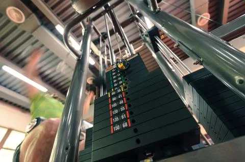 Motion blurred unrecognizable person doing upper traction gym machine Foto stock