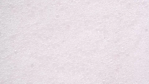 Motion of bubbles, macro. Foam bubble from soap, shower gel or shampoo top .. Stock Footage 293736333
