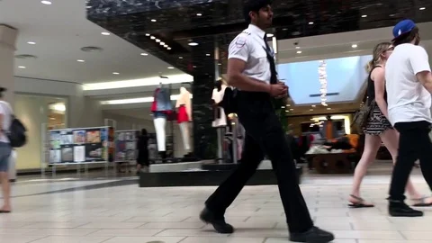 Motion of camera chasing security working inside Coquitlam shopping mall Stock Footage 76111413
