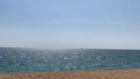 The motion with the camera panning from left to right of the sparkling blue sea Stock Footage 196979115