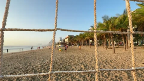 Motion close up along Beach Volleyball Net with Players in blurred Background at 스톡 동영상 342581847