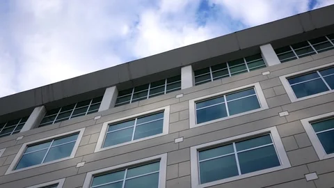 Motion of cloudy sky with illuminated reflected glass facade Stock Footage 79203057