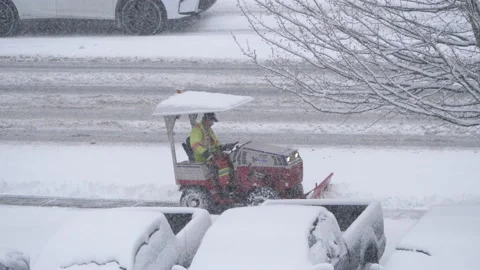 Motion of compact tractor with snow plowing equipment cleaning city sidewalk Stock Footage 86406957