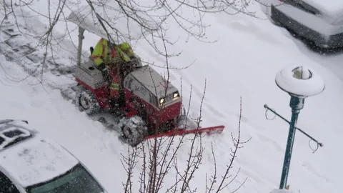 Motion of compact tractor with snow plowing equipment cleaning parking lot Stock Footage 108252137