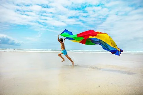 Motion concept boy run on beach with fabric flying 스톡 사진