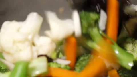 The motion of cooking vegetables with steam in a pan Stock Footage 219778532