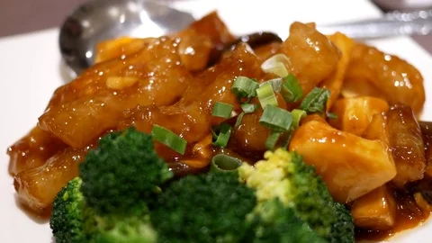 Motion of deep fried pork shoulder and broccoli on table inside restaurant Stock Footage 81759175