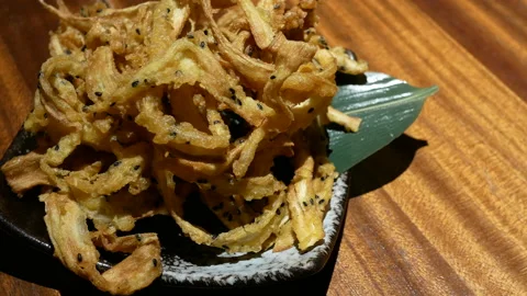 Motion of deep fried shredded burdock appetizers on table inside restaurant Stock Footage 96783011