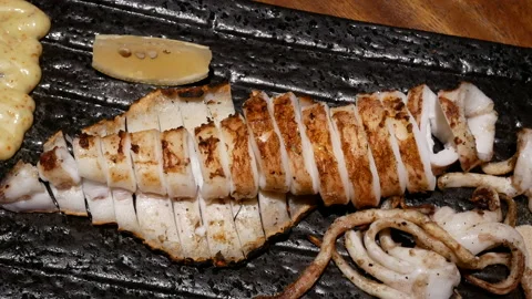 Motion of deep water dressed squid and lemon on table Stock Footage 96825685