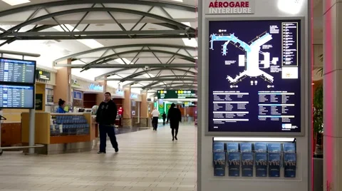 Motion of direction sign and passengers with luggage inside YVR airport Video stock 61121247