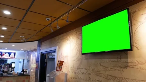 Motion of display tv with green screen inside restaurant on wall Stockbeeldmateriaal 72714129