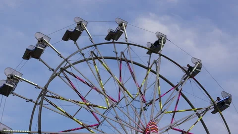 The motion of empty riding Ferris wheel against a blue sky w Video stock 150540419