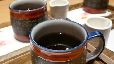 Motion of hot black tea on table inside Japanese restaurant with 4k resolution Stock Footage 93969433