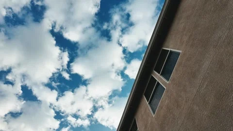 Motion lapse looking up at the side of house with clouds Video stock 257930908