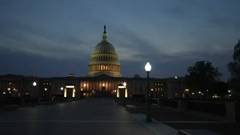 Motion to left showing the US Capitol with lights and flags waving in Washington Stock Footage 238954917