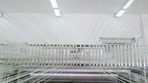 Motion from loom past moving threads to racks with bobbins girl controls process Stock Footage 93533330