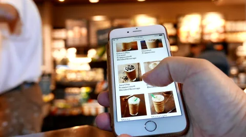 Motion of man browsing Starbucks drink menu on phone Video stock 67496106
