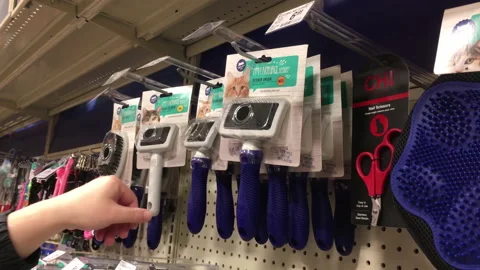 The motion of man buying cat slicker brush inside Petsmart store Stock Footage 163316492