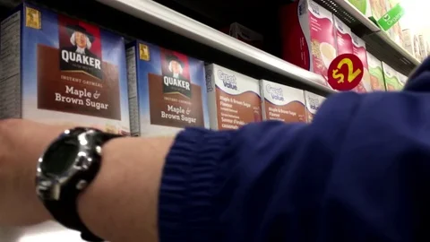 Motion of man buying Great value maple and brown sugar flavour instant oatmeal Stock Footage 75330563