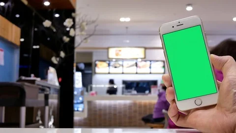 Motion of man holding green screen phone with blur people eating food Stock Footage 83668357