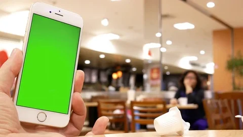 Motion of man holding green screen phone with blur people eating food Video stock 84004132