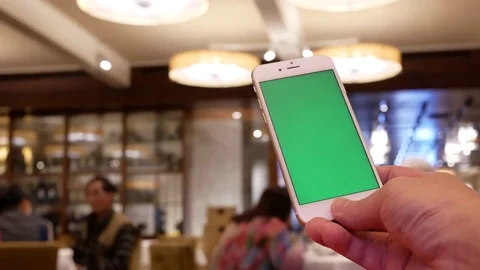 Motion of man holding green screen phone with blur people eating food Stock Footage 84190041