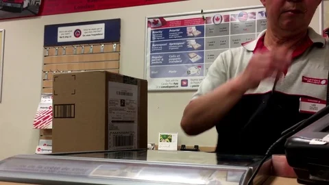 Motion of man mailing parcel at post office inside shopper drug mart store Stock Footage 77530962