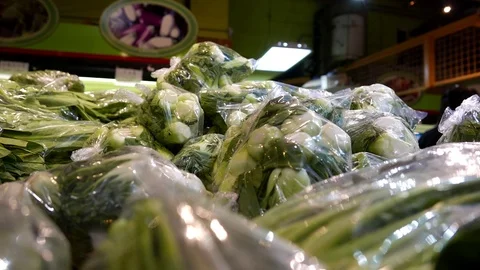 Motion of man selecting vegetable inside Chinese supermarket Stock Footage 71263749