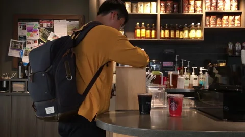 The motion of a man taking his drink inside a Starbucks store with 4k resolution Stock Footage 265974407