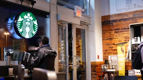 The motion of a man taking a napkin on a table inside a Starbucks store Video stock 172463098