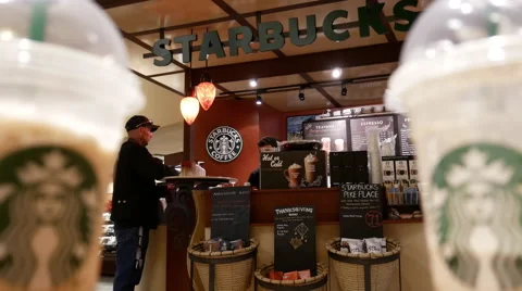Motion of man waiting and taking his coffee inside Starbucks store Stock Footage 68828201