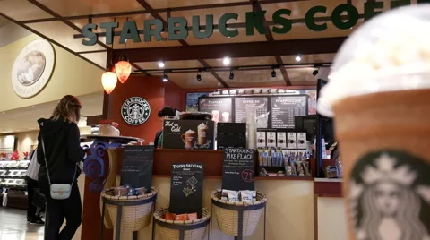 Motion of man waiting and taking her coffee inside Starbucks store Stock Footage 68931852