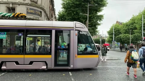 Motion of modern Dublin Luas tram, tramway. People are crossing road. Ireland Stock Footage 247549353