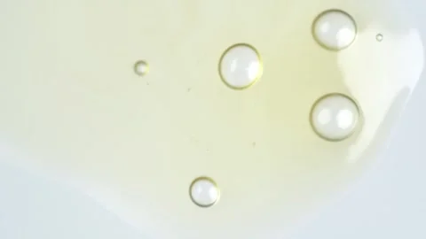 Motion of molecule bubbles in a cosmetic serum, macro. Yellow transparent c.. Stock Footage 269023530