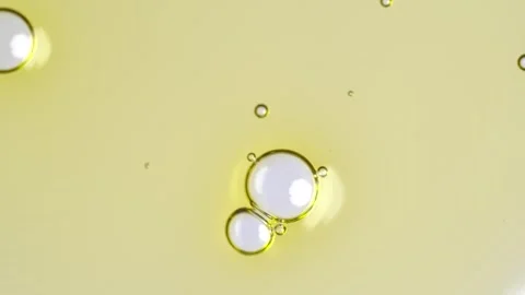 Motion of molecule bubbles in a cosmetic serum, macro. Transparent yellow c.. Stock Footage 269025959