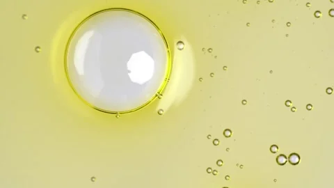 Motion of molecule bubbles in a cosmetic serum, macro. Transparent yellow c.. Stock Footage 269026530