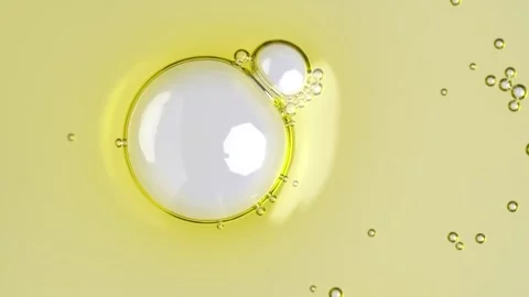 Motion of molecule bubbles in a cosmetic serum, macro. Transparent yellow c.. Stock Footage 274547794
