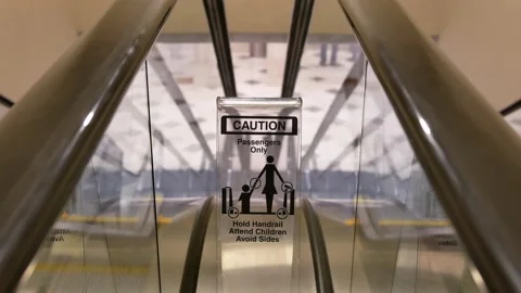 Motion of moving empty escalator and caution sign inside shopping mall Stock Footage 103437844