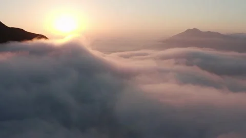 Motion over heavy white clouds against sun and mountains Stock Footage 143685863