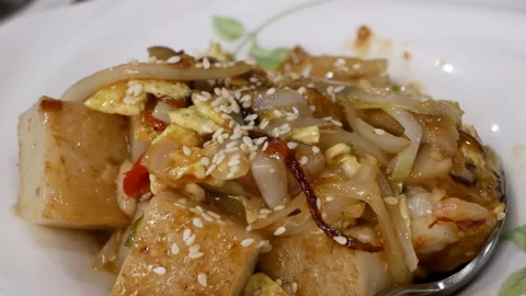 Motion of pan fried turnip cake dim sum inside Chinese restaurant Stock Footage 102588101