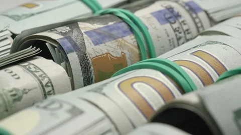 Motion past rolled dollar bills with rubber bands closeup Stock Footage 124668454